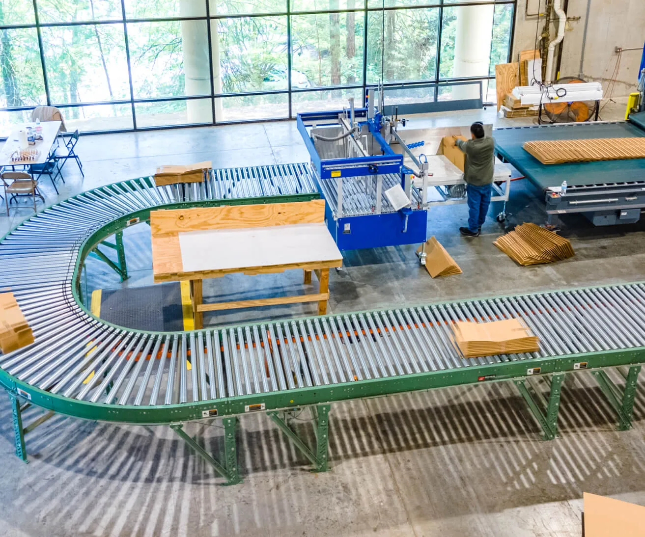 Roller conveyor feeding the gluer and stitcher station